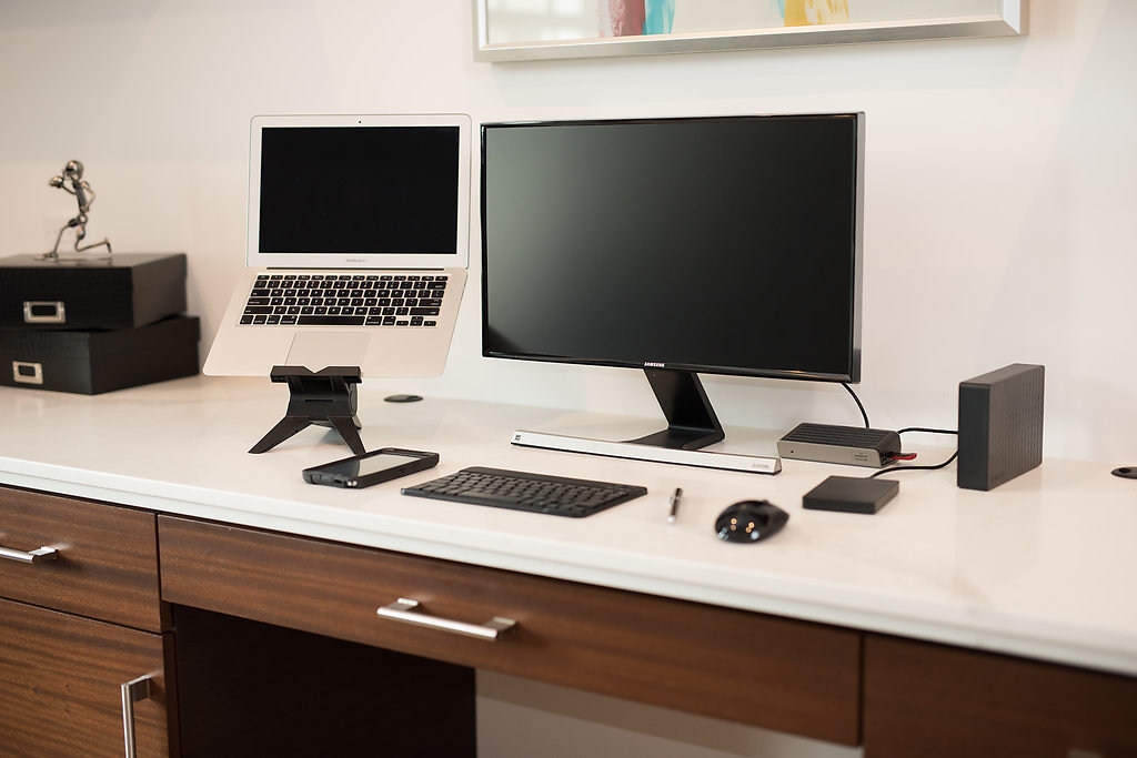 A home workspace setup -- complete with a universal docking station, a laptop, laptop stand, monitor, and wireless keyboard and mouse -- can improve the productivity of remote workers